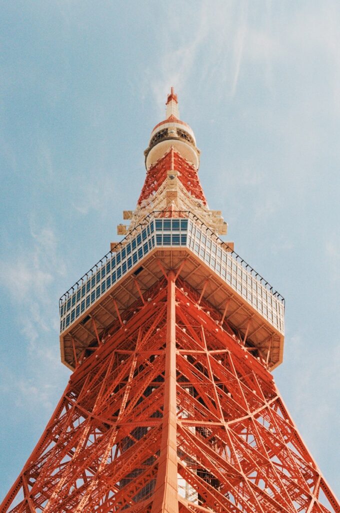Tokyo tower soars against a clear, blue sky.